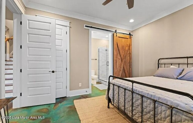 bedroom with ornamental molding, a barn door, and ensuite bath