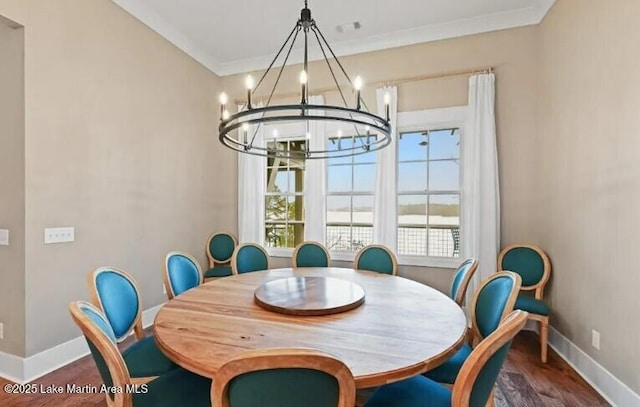 dining area featuring ornamental molding, dark hardwood / wood-style floors, and a chandelier