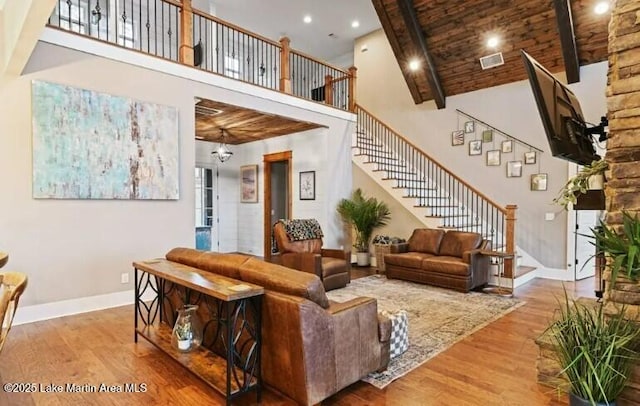 living room featuring wooden ceiling, hardwood / wood-style floors, and a high ceiling