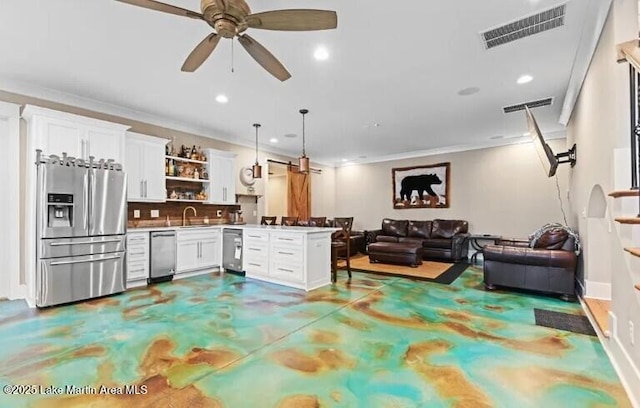 kitchen featuring sink, kitchen peninsula, pendant lighting, stainless steel appliances, and white cabinets