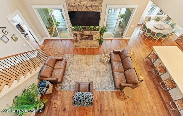 living room featuring hardwood / wood-style flooring and a stone fireplace