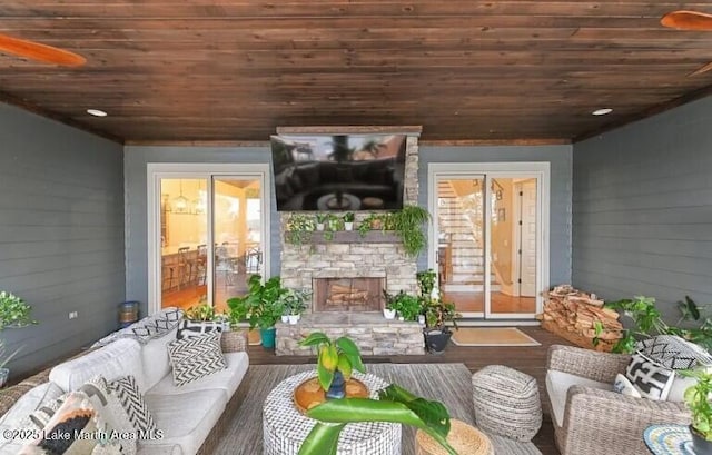 living room featuring wood ceiling, wood-type flooring, an outdoor stone fireplace, and wood walls