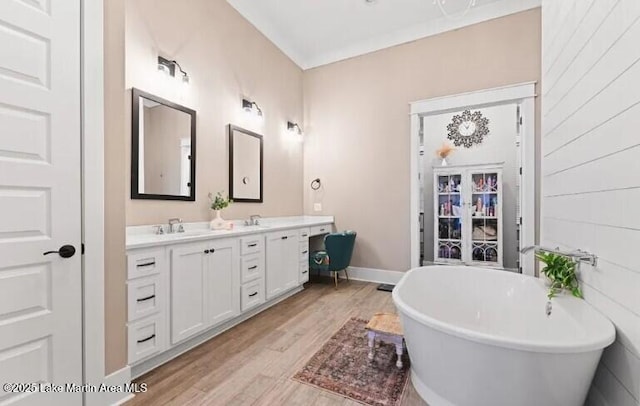 bathroom with a bathing tub, hardwood / wood-style floors, and vanity