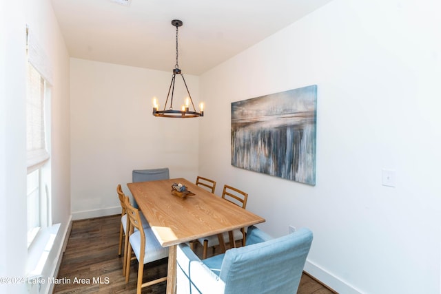 dining room with a notable chandelier and dark wood-type flooring