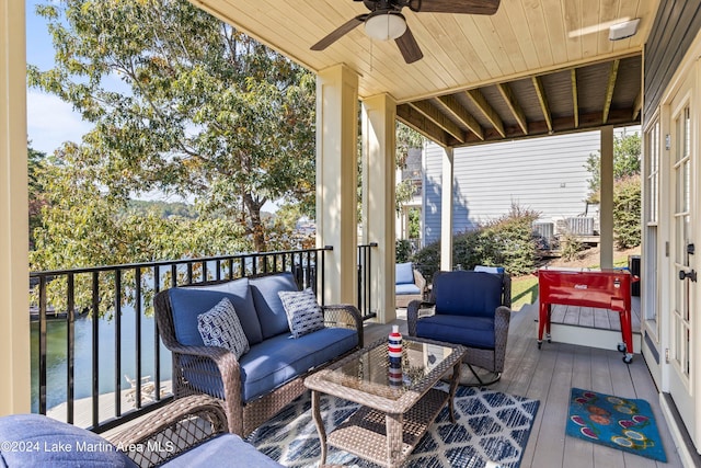 wooden deck featuring an outdoor living space, a water view, and ceiling fan