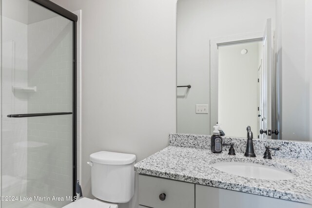 bathroom featuring walk in shower, vanity, and toilet