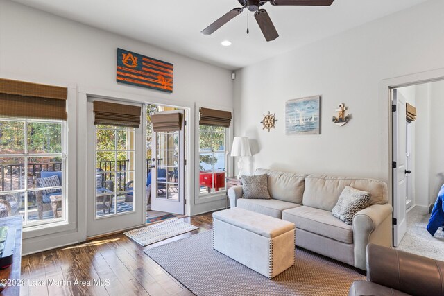 living room featuring ceiling fan and dark wood-type flooring