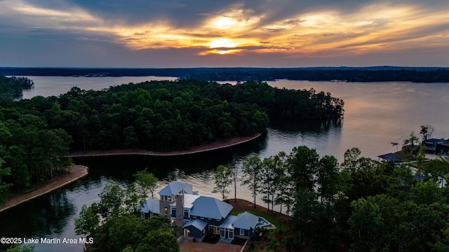 aerial view at dusk featuring a water view