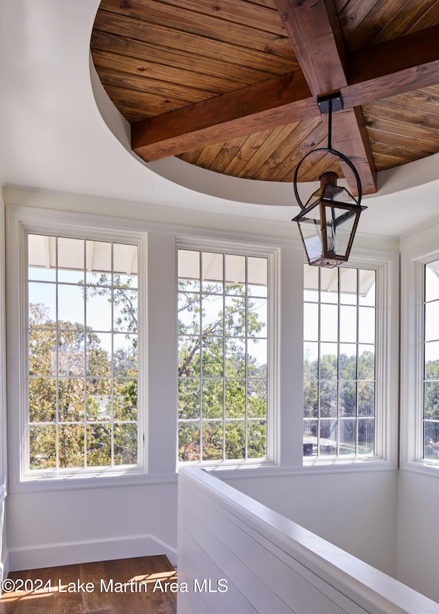 unfurnished sunroom featuring beam ceiling and wood ceiling