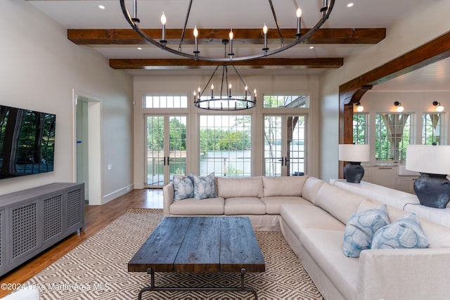 living room with beamed ceiling, french doors, an inviting chandelier, and light hardwood / wood-style flooring