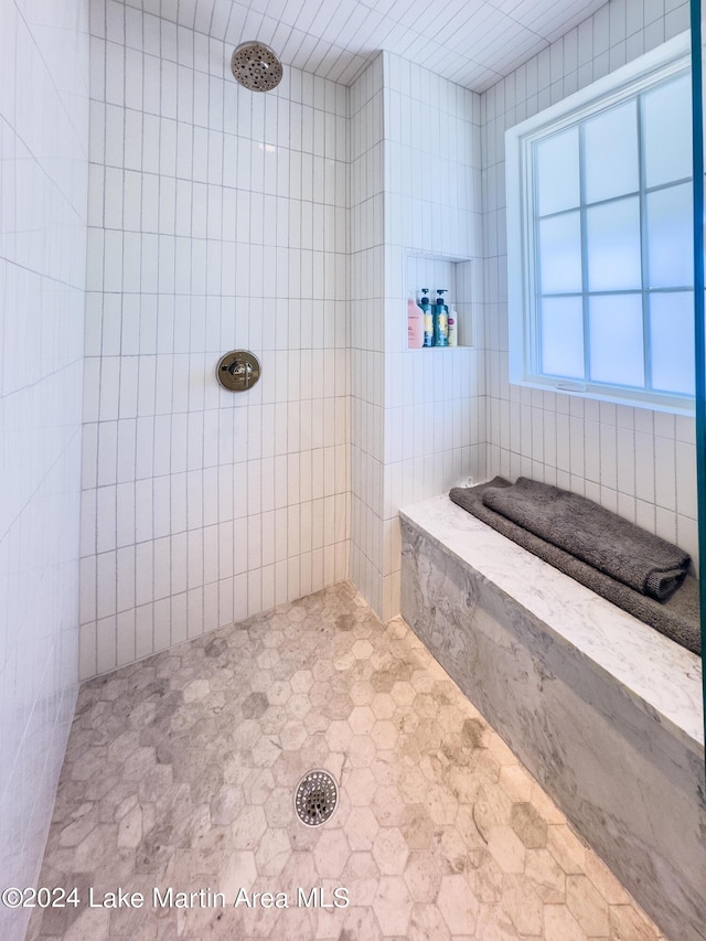 bathroom featuring a tile shower and tile walls