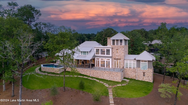 back house at dusk featuring a yard