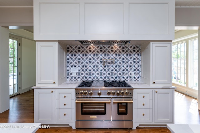 kitchen featuring white cabinetry, double oven range, a wealth of natural light, and backsplash