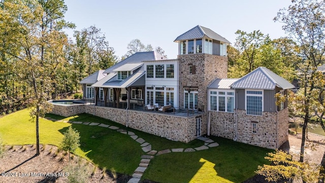 back of property featuring an in ground hot tub, a lawn, and a patio area