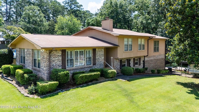 207 Mcdonald St, Dadeville, AL 36853 - split level home with a chimney, brick siding, and a front lawn