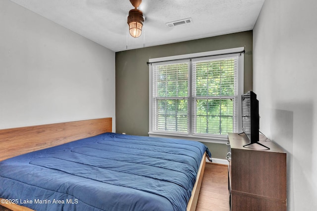 207 Mcdonald St, Dadeville, AL 36853 - bedroom with wood finished floors, a textured ceiling, and ceiling fan