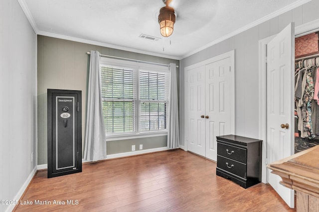 207 Mcdonald St, Dadeville, AL 36853 - unfurnished bedroom with multiple closets, crown molding, wood finished floors, and ceiling fan