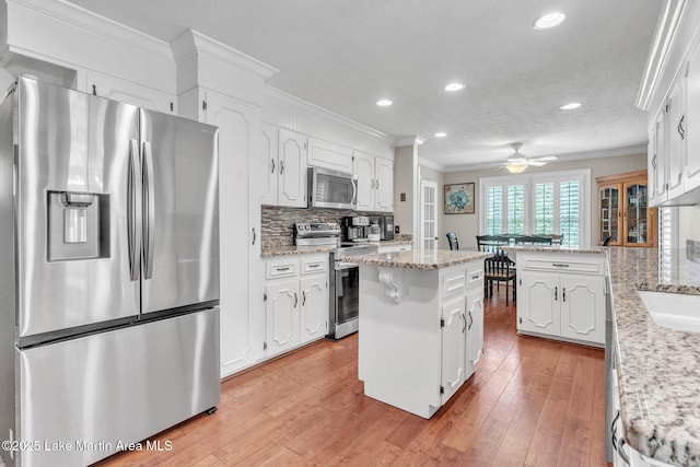 207 Mcdonald St, Dadeville, AL 36853 - kitchen featuring appliances with stainless steel finishes, ornamental molding, white cabinets, a peninsula, and recessed lighting