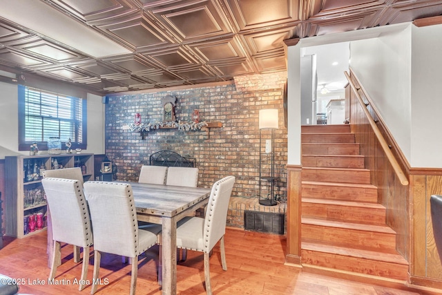 207 Mcdonald St, Dadeville, AL 36853 - dining room with an ornate ceiling, brick wall, stairway, and light wood-style floors