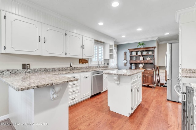207 Mcdonald St, Dadeville, AL 36853 - kitchen featuring dishwasher, crown molding, freestanding refrigerator, white cabinets, and a center island