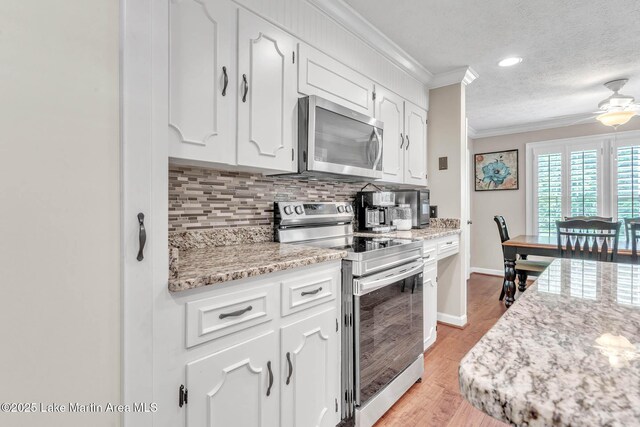 207 Mcdonald St, Dadeville, AL 36853 - kitchen featuring appliances with stainless steel finishes, ornamental molding, decorative backsplash, a textured ceiling, and white cabinets