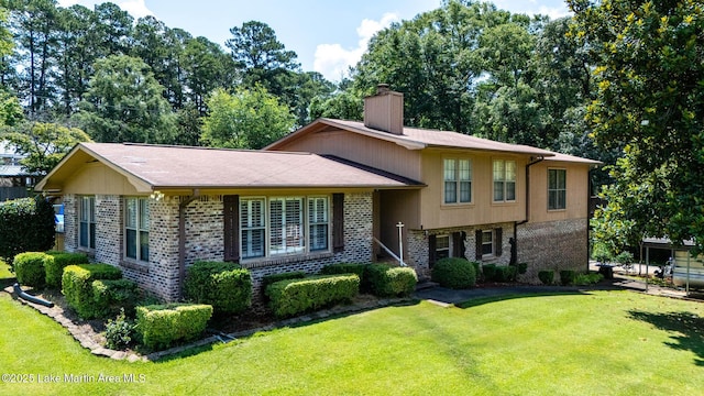 207 Mcdonald St, Dadeville, AL 36853 - split level home featuring a chimney, brick siding, and a front lawn