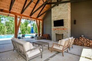 view of patio / terrace featuring an outdoor pool and an outdoor stone fireplace