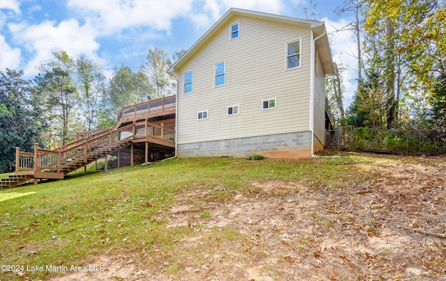 back of house featuring a lawn and a wooden deck