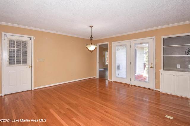 interior space featuring crown molding, light wood-type flooring, and a textured ceiling