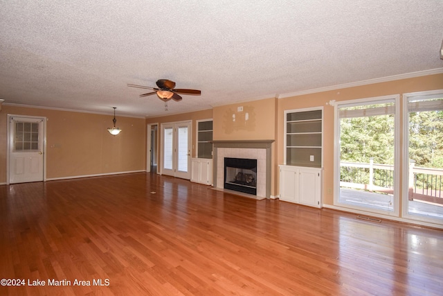 unfurnished living room with ceiling fan, hardwood / wood-style floors, and a textured ceiling