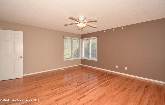 empty room with light hardwood / wood-style floors and a textured ceiling