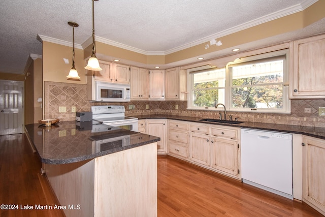 kitchen with kitchen peninsula, white appliances, crown molding, sink, and light hardwood / wood-style floors