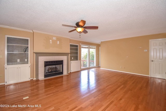 unfurnished living room with a tile fireplace, a textured ceiling, hardwood / wood-style flooring, and ceiling fan