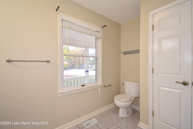 bathroom featuring tile patterned flooring, toilet, and a textured ceiling