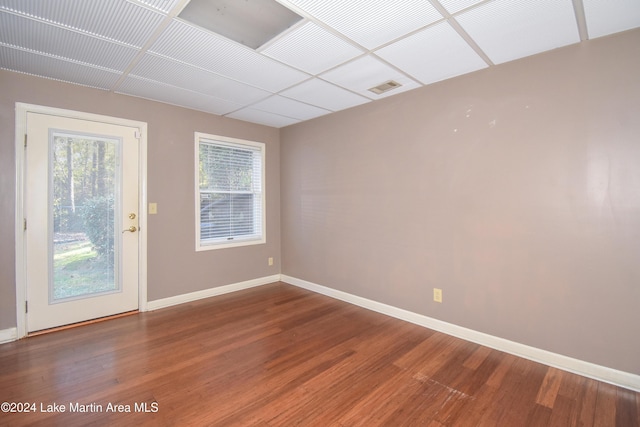 empty room with a paneled ceiling and hardwood / wood-style flooring