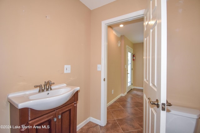 bathroom with tile patterned flooring, vanity, and toilet