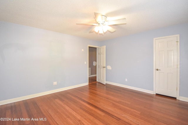 unfurnished room with ceiling fan, dark hardwood / wood-style flooring, and a textured ceiling