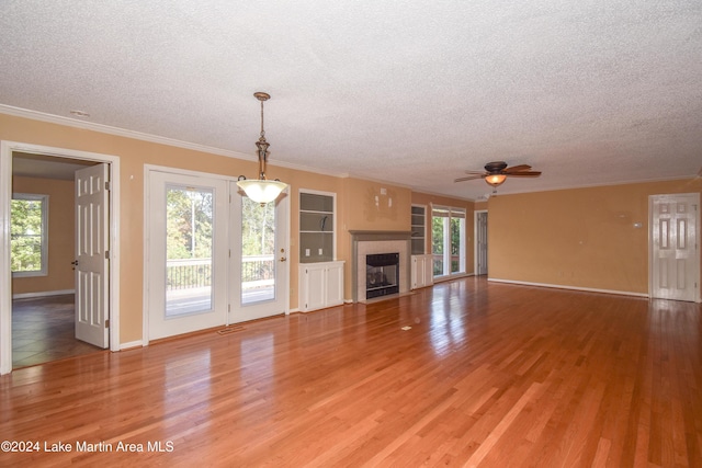 unfurnished living room featuring hardwood / wood-style floors, a healthy amount of sunlight, and a textured ceiling