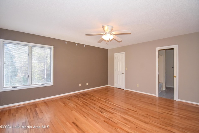 spare room with ceiling fan, light wood-type flooring, and a textured ceiling