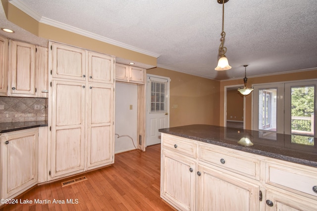 kitchen with light hardwood / wood-style flooring, pendant lighting, and ornamental molding