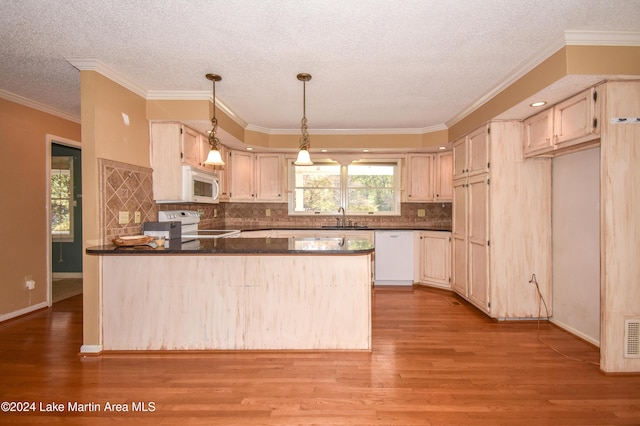 kitchen featuring white appliances, sink, light hardwood / wood-style flooring, ornamental molding, and kitchen peninsula