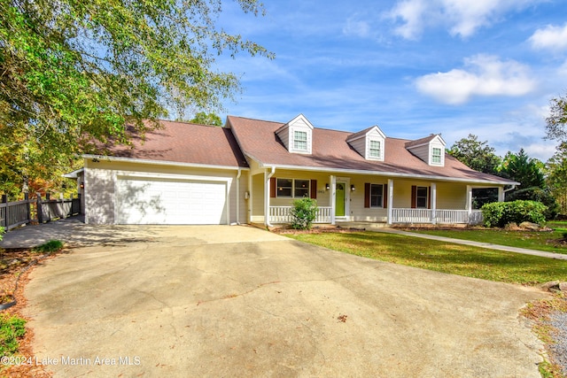 new england style home featuring a porch, a garage, and a front yard