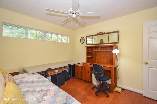 bedroom featuring ceiling fan, wood-type flooring, and a textured ceiling