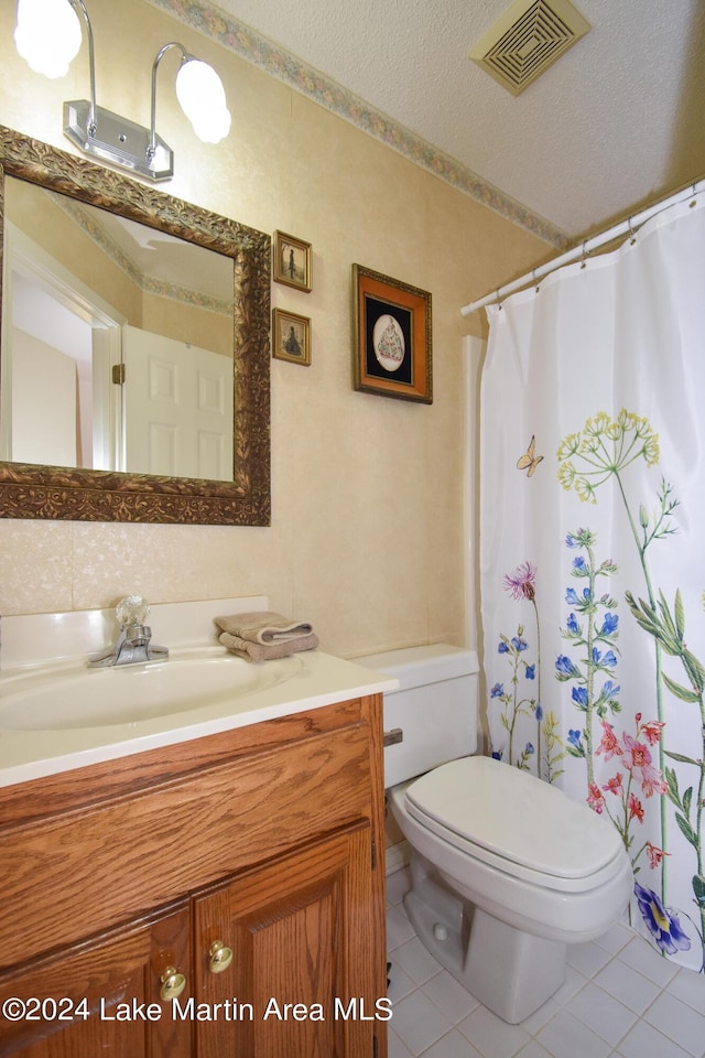 bathroom featuring walk in shower, vanity, a textured ceiling, tile patterned flooring, and toilet