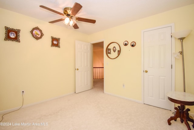 carpeted spare room with ceiling fan