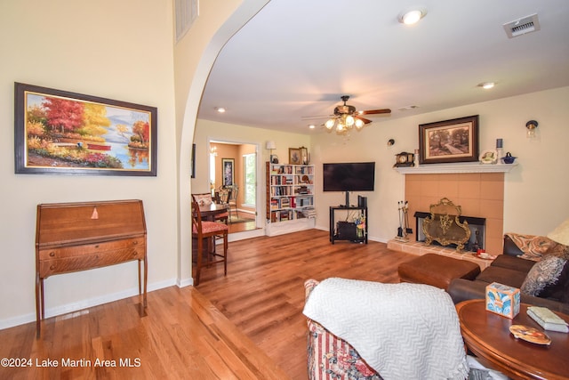 living room with a fireplace, ceiling fan, and hardwood / wood-style floors