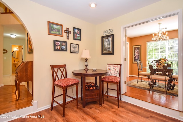 sitting room with hardwood / wood-style flooring and an inviting chandelier