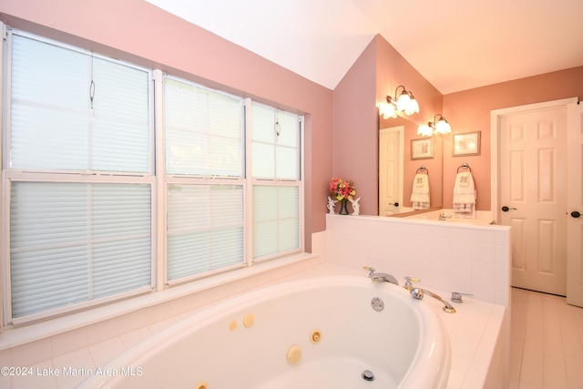 bathroom with tiled bath and vaulted ceiling