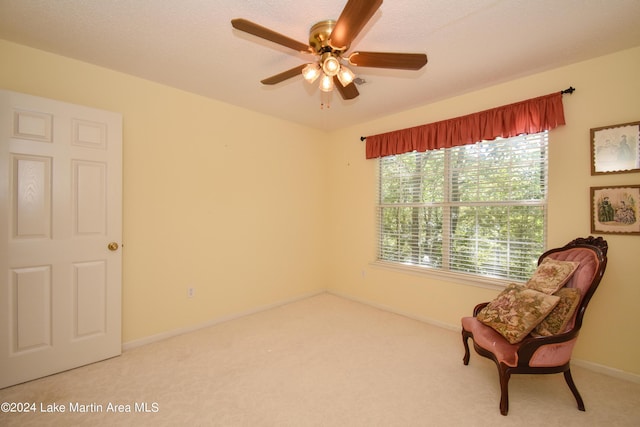 sitting room featuring ceiling fan, light colored carpet, and a wealth of natural light