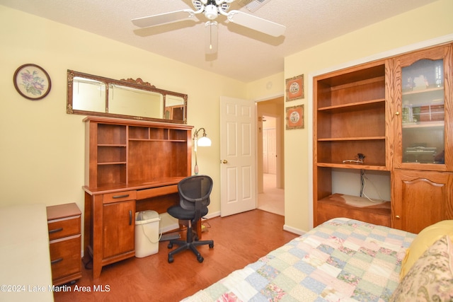 bedroom with ceiling fan, light hardwood / wood-style flooring, and a textured ceiling